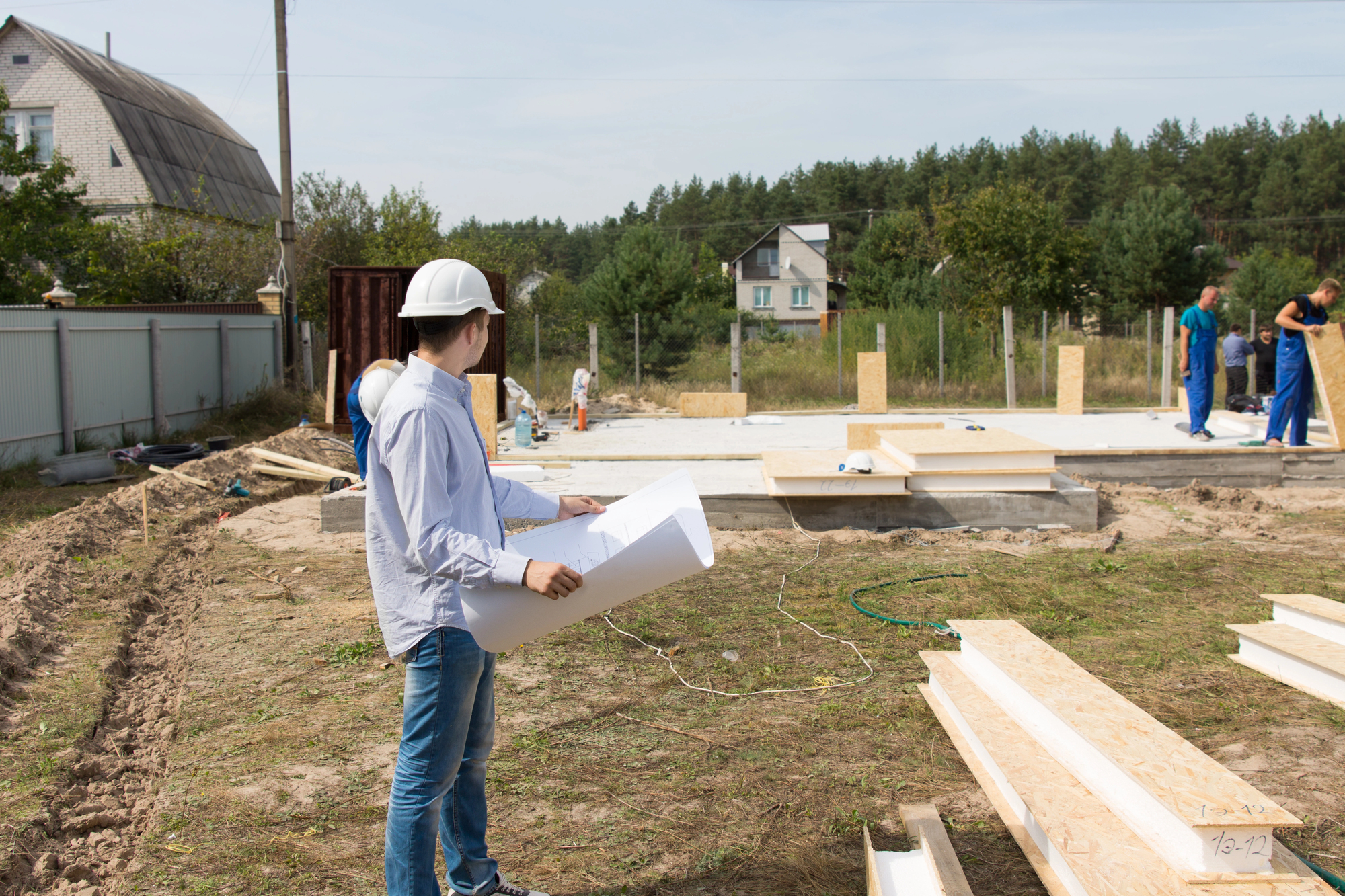 Inżynier z projektem na placu budowy domu
